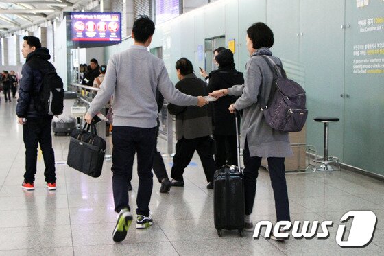 본문 이미지 - 가벼운 발걸음으로 출국장을 향하고 있는 여행객의 모습이 한결 밝아 보인다. 겨울 외투가 필요 없는 여행지로 떠날 경우, 인천공항의 '겨울 외투 보관 서비스'를 이용하는 것도 좋다.  2015.11.25. 뉴스1트래블 ⓒ News1travel 조용식 기자