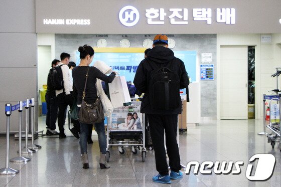 본문 이미지 - '겨울 외투 보관 서비스'를 제공하는 한진택배에서 한 여행자가 겨울 외투를 보관하려고 줄을 서고 있다.  2015.11.25. 뉴스1트래블 ⓒ News1travel 조용식 기자