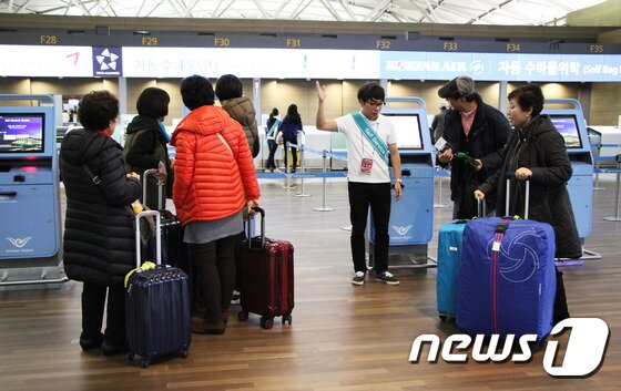 본문 이미지 - 25일 자동 탑승수속 서비스 안내 도우미가 인천공항 이용객에게 빠르고 간편한 셀프 체크인과 자동 수화물 위탁에 대해 안내하고 있다. 하지만 아직까지 자동 탑승수속 서비스를 이용하는 여행자는 크게 눈에 띄지 않는다. 2015.11.25/뉴스1트래블 ⓒ News1 travel 조용식 기자