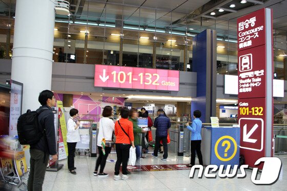 본문 이미지 - 보팅패스에 탑승구가 101~132에 해당할 경우 탑승동을 따라 내려가 셔틀트레인을 이용하면 된다. 출국심사 후 바로 쇼핑하는 여행자들이 있는데, 셔틀트레인을 타고 이동하는 101~132 탑승구에도 쇼핑할 수 있는 면세점이 있다. 2015.11.25/뉴스1트래블 ⓒ News1 travel 조용식 기자