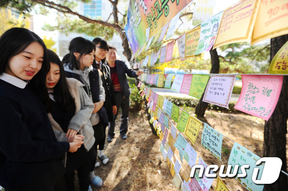(대구=뉴스1) 이종현 기자 = 수능시험을 일주일 앞둔 5일 오후 대구 북구 국우동 학남 고등학교에서 학생들이 수능 대박을 기원하는 메시지를 소망나무에  붙이고 있다.2015.11 …
