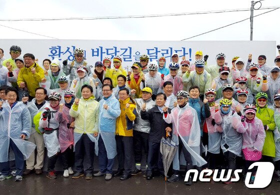 본문 이미지 - 234km 구간의 '제주환상 자전거길' 개통식에 200여 명의 자전거 동호인들이 함께 참석해 화이팅을 외치고 있다. ⓒ News1 travel 사진 제공 / 행정자치부