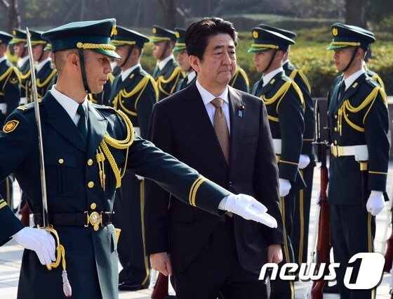본문 이미지 - 아베 신조(安倍晋三) 일본 총리가 지난달 16일 도쿄에 있는 방위성 청사에서 의장대 사열을 하고 있다. 이날 아베 총리는 청사 강당에서 자위대 고급간부 회동에서 훈시했다. ⓒ AFP=뉴스1 