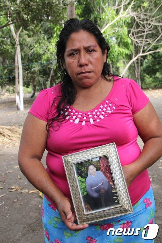 본문 이미지 - 표류 중 숨진 에즈키엘 코르도바의 사진을 들고 있는 유가족. ⓒ News1