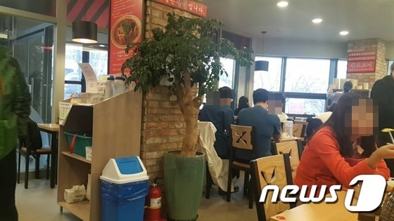 지난 18일 서울 동대문구 A대학병원 근처의 한 음식점. 의사 3명이 가운과 이너웨어를 입은 채 식사하고 있다.© News1