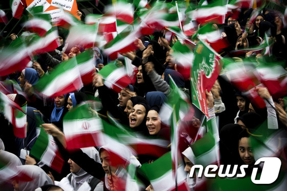 국기를 흔들며 이란 혁명 36주년을 기념하는 이란 여학생들.© AFP=뉴스1