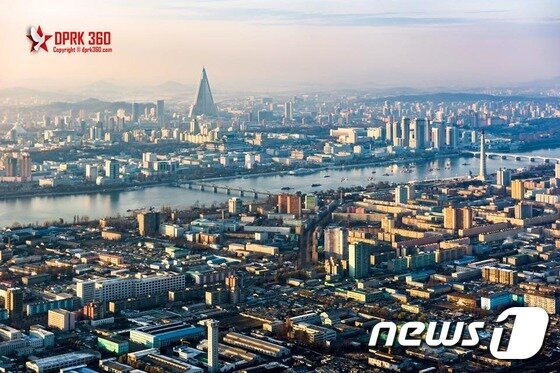 본문 이미지 - 싱가포르의 북한 전문 사진작가 아람 판씨는 최근 자신의 페이스북 계정(www.facebook.com/dprk360)에 '평양 비행기 관광' 사진을 공개했다. 가운제 삼각형 모양의 건물이 평양에서 가장 높은 '류경 호텔'이다. ⓒ News1