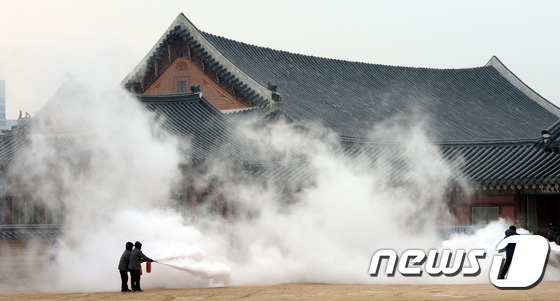 (서울=뉴스1) 허경 기자 = '문화재 방재의 날'인 10일 오후 서울 종로구 경복궁 교태전에서 열린 화재진압 대응훈련에서 직원들이 초기 화재진압을 하고 있다. 2015.2.10/ …