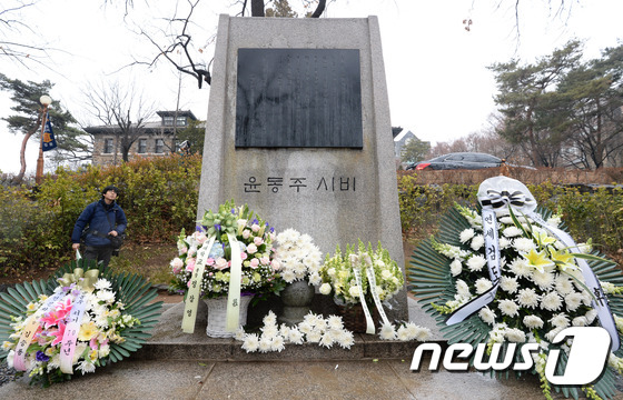 (서울=뉴스1) 신웅수 기자 = 윤동주 시인 70주기인 16일 오전 서울 서대문구 연세대학교 신촌캠퍼스 내 윤동주 시비에 시민들이 헌화한 꽃들이 놓여 있다. 2015.2.16/뉴스 …