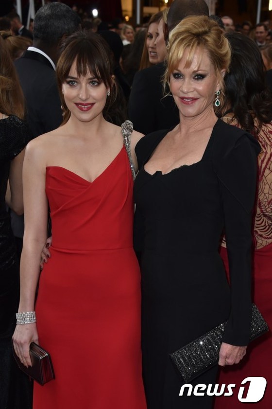 (할리우드 AFP=뉴스1) 이기창 = 가족배우로 유명한 멜라니 그리피스(오른쪽)가 22일(현지시간) 할리우드에서 열린 제87회 아카데미상 시상식에 참석, 딸 다코타 존슨과  포즈를 …