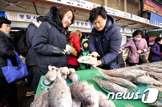 대구시 중구 서문시장에 설 명절 음식을 준비하게 위해 나온 시민들이 어물전에서 상어고기(돔베기)를 구입하고 있다. 2015.2.8./뉴스1 © News1 정훈진 기자