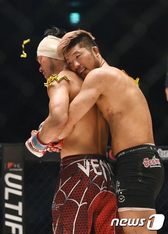 본문 이미지 - 격투기 선수 권아솔(오른쪽)이 21일 오후 서울 장충체육관에서 열린 "굽네치킨 로드FC 022"의 경기에서 챔피언 방어전에 성공한 뒤 이광희를 안아주고 있다. ⓒ News1 권현진 기자