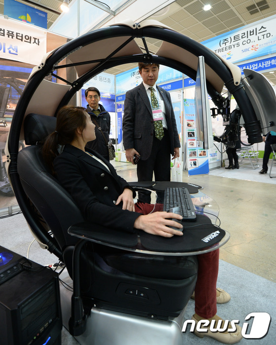 (서울=뉴스1) 허경 기자 = 25일 서울 강남구 코엑스에서 열린 제25회 서울국제소싱페어에서 업체 관계자가 누워서 컴퓨터를 즐길 수 있는 컴퓨터의자를 시연하고 있다. 2015.3 …