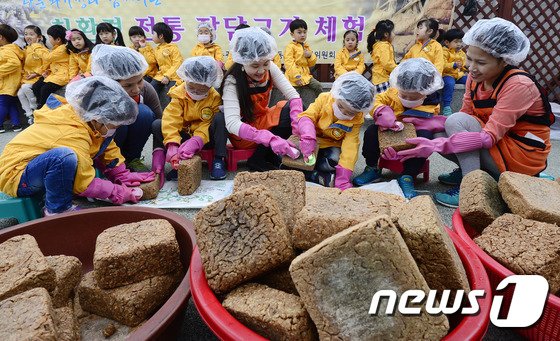 본문 이미지 - 31일 서울 성동구 상왕십리동 주민센터 옥상체험장에서 이주민여성과 어린이들이 전통 장 담그기 체험을 하고 있다. 이날 담근 장이 숙성되면 3kg 단위로 제품화해 주민들에게 저렴하게 판매할 예정이다. 2015.3.31/뉴스1 ⓒ News1 박지혜 기자