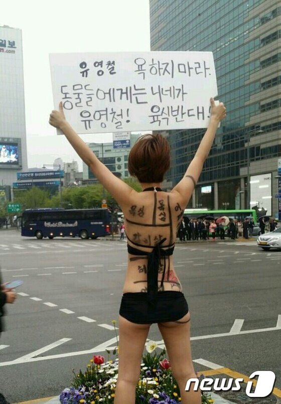 본문 이미지 - 클럽에서 나체 상태로 격렬하게 춤을 춰 화제가 됐던 일명 ‘아우디녀’가 16일 오전 서울 종로구 광화문 광장에서 "유영철 욕하지 마라. 동물들에게는 니네가 유영철! 육식반대"라고 쓰인 피켓을 들고 시위를 하고 있다. 이 여성은 지난 13일에도 광화문 광장에서 탱크탑과 핫팬츠를 입고 시위를 벌였다.(사진제공=종로경찰서 제공) 2015.4.16/뉴스1 ⓒ News1