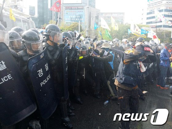 24일 민주노총 대구본부 노조원들이 새누리당 대구시당 방향으로 행진을 시도하자 경찰이 캡사이신 성분의 최루액을 뿌리며 시위대를 해산시키고 있다. 이날 총파업 집회에 참가한 민주노총 대구본부 노조원들은 대구시 수성구 범어동 범어네거리를 점거한 채 경찰과 대치했다. 2015.4.24/뉴스1 ⓒ News1 배준수 기자