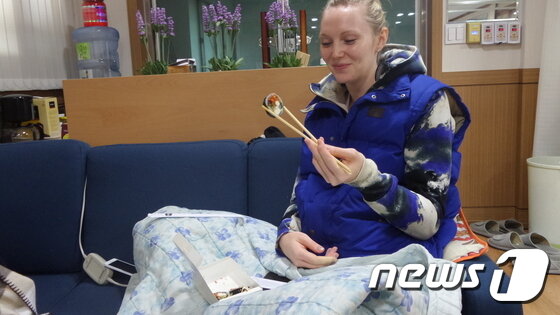 본문 이미지 - 전기 장판에 앉아 능숙한 젓가락질로 김밥을 먹고 있는 니콜. /뉴스1 ⓒ News1