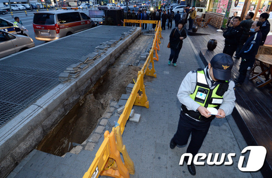 (서울=뉴스1) 신웅수 기자 = 7일 오후 서울 동대문구 지하철 장한평역 1번 출구 환기구 부근에 2m 가량 깊이의 싱크홀이 발생해 서울시 관계자들이 사고현장을 수습하고 있다.이날 …