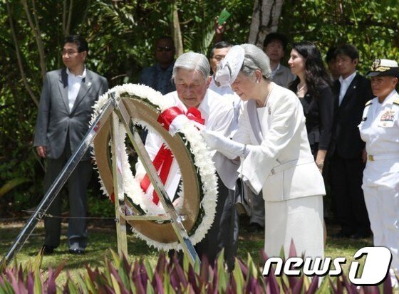 본문 이미지 - 남태평양 팔라우를 방문중인 아키히토 일왕 부부가 9일 2차 대전 격전지 중 하나였던 페리류섬에 있는 전몰자 위령비에 헌화하고 있다. ⓒ AFP=News1