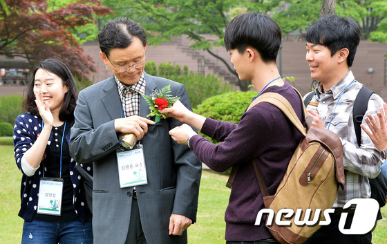 (수원=뉴스1) 이재명 기자 = 스승의 날을 맞이한 15일 오후 경기도 수원시 아주대학교 교정에서 학생들이 교수님께 카네이션을 달아주고 있다. 2015.5.15/뉴스1