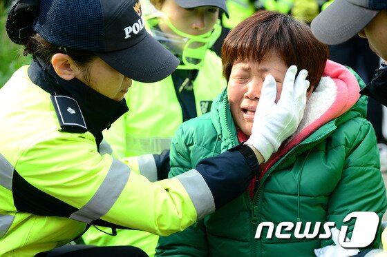 본문 이미지 - &acute;세월호 참사&acute; 5일 뒤인 지난해 4월20일 실종자 가족이 눈물을 흘리자 눈물을 닦아주던 여경. ⓒ News1