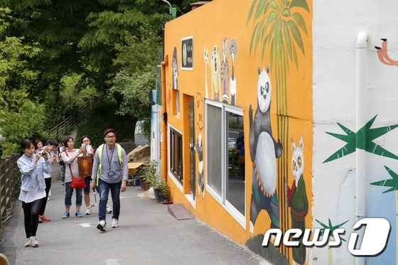 (전주=뉴스1) 김대웅 기자 = 9일 오전 전북 전주시 교동 자만마을에서 열린 \'제1회 자만마을 공감 문화축제\'에서 관광객들이 벽화거리를 걷고 있다. ‘사람과 사람의 만남 그리 …