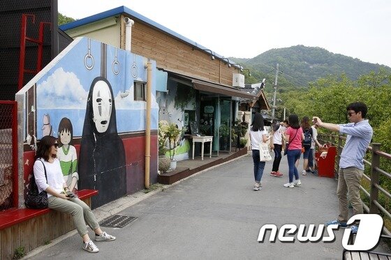 본문 이미지 - 전주시 교동 자만마을에서 관광객들이 벽화거리를 배경으로 사진을 찍고 있다. /뉴스1 ⓒ News1 DB