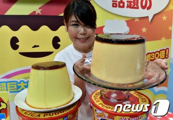 (도쿄 AFP=뉴스1) 최은지 = 일본 도쿄에서 18일(현지시간) 열린 도쿄장난감쇼에서 한 직원이 약 30인분의 카라멜 푸딩과 이 푸딩을 만드는 기계 'Super Giga Pudd …