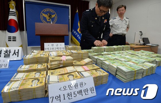 본문 이미지 - 2서울 광진경찰서에서 경찰이 해외로 도주하려던 보이스피싱 조직원들의 압수품을 공개하고 있다. .  2015.6.2/뉴스1 ⓒ News1 허경 기자