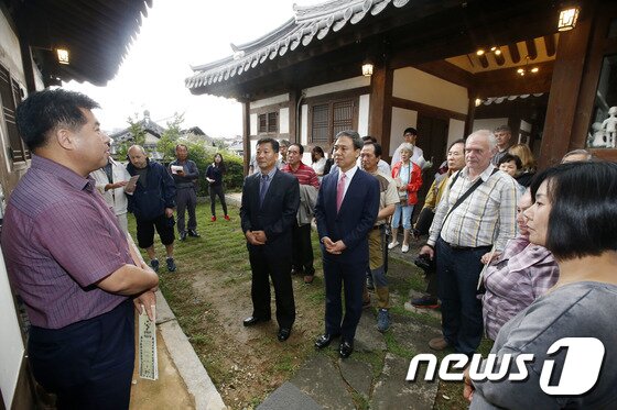 본문 이미지 - 김승수(가운데) 전주시장이 한옥마을 꽃숙이 공예공방촌에서 외규장각 의궤반차도(영조정순왕후 가례도감 의궤) 재현사업이 완료 보고를 받고 있다.(전주시제공)2015.6.28/뉴스1ⓒ News1
