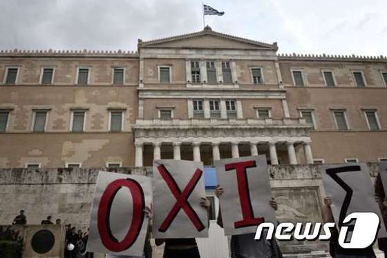 본문 이미지 - 아테네에 있는 그리스 의회 앞에서 반긴축 시위가 벌어지고 있다. 'OXI'는 그리스어로 'NO'라는 의미이다. ⓒ AFP=News1