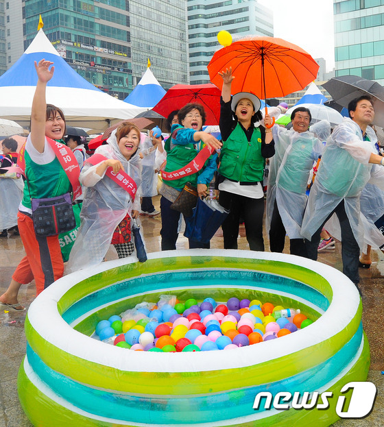 (부산=뉴스1) 이승배 기자 = 20일 오후 부산 해운대 해수욕장 이벤트 광장에서 열린 ‘메르스 종식 선포식’에 참석한 시민들이 메르스 종식 물풍선 던지기 퍼포먼스를 하고 있다.부 …