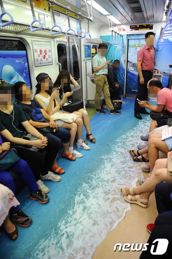(부산=뉴스1) 이승배 기자 = 29일 오후 시원한 바다 이미지로 꾸며진 부산도시철도 2호선 전동차 내부에 승객들이 탑승하고 있다.부산교통공사는 여름을 맞아 해운대와 광안리 등 부 …