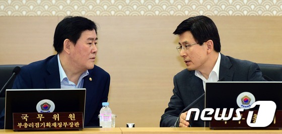 (세종=뉴스1) 장수영 기자 = 황교안 국무총리가 7일 정부세종청사 국무회의장에서 열린 청와대-세종청사 영상 국무회의에서 최경환 경제부총리 겸 기획재정부 장관과 대화를 나누고 있다 …