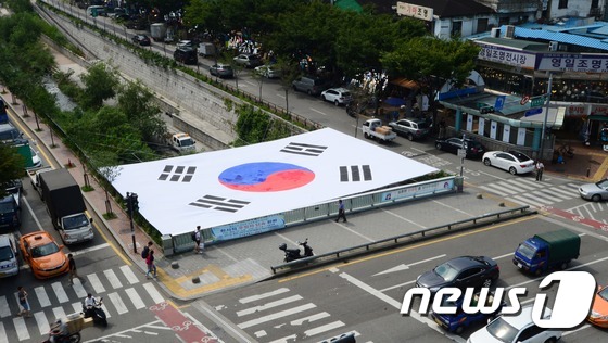 (서울=뉴스1) 양동욱 기자 = 70번째 광복절을 닷새 앞둔 10일 오후 서울 청계4가 배오개다리에 서울시민들이 제작한 대형 태극기가 걸려 있다. 이 태극기는 약 2천명이 직접 바 …