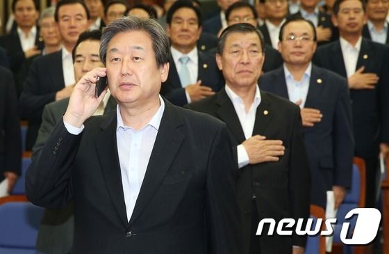 새누리당 김무성 대표가 11일 오후 국회에서 열린 의원총회에서 국기에 대한 경례 도중 누군가로부터 걸려온 전화를 받고 있다. © News1 오대일 기자