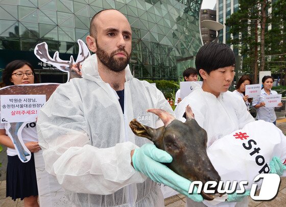 본문 이미지 - 20일 오후 서울 중구 서울시청 앞에서 열린 '서울대공원 전시동물 도축장 판매 금지 촉구 기자회견'에서 에이제이 가르시아 동물단체 케어 미국법인 대표(왼쪽)가 서울대공원 동물원에서 도축농장으로 밀반출되어 도축당한 새끼흑염소의 머리를 들어보이고 있다. ⓒ News1