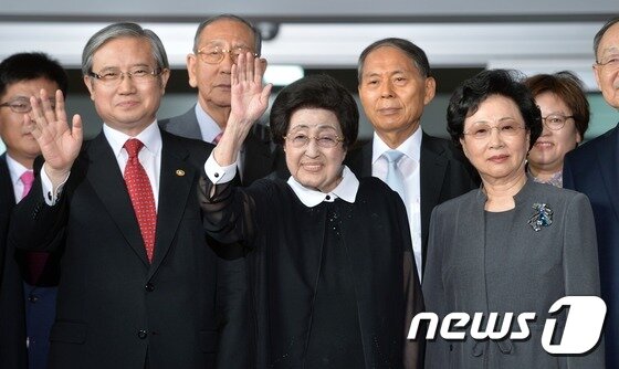 본문 이미지 - 고(故) 김대중 전 대통령의 부인 이희호 여사가 5일 방북길에 오르기 위해 서울 김포공항으로 들어서며 취재진을 향해 손을 흔들고 있다. 이번 방북단에는 이 여사를 비롯해 수행단장인 김성재 전 문화부 장관, 백낙청 서울대 명예교수, 장충식 단국대 이사장, 최용준 천재교육 회장, 윤철구 김대중평화센터 사무총장 등 18명으로 구성됐다. 2015.8.5/뉴스1 ⓒ News1 민경석 기자