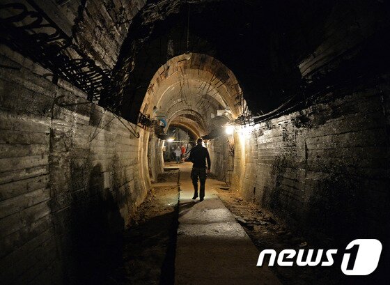 본문 이미지 - 나치의 황금열차가 묻힌 것으로 추정되는 크시아즈성 지하를 걷고 있는 남성. ⓒ AFP=뉴스1