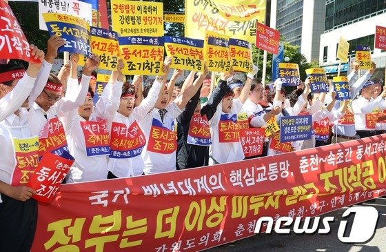 본문 이미지 - 강원도의회와 춘천·속초·화천·양구·인제 등 5개 시·군의원들이 2015년 9월 7일 당시 서울 여의도 새누리당사 앞에서 열린 '동서 고속화 철도 조기착공 촉구집회'에서 피켓을 들고 구호를 외치고 있다. 참가자들은 이 자리에서 "동서고속화철도는 박근혜 대통령의 1순위 강원도 공약이자 대통령이 강조한 '유라시아 이니셔티브'를 실현할 핵심 철도망으로 도내 북부지역의 경제 발전을 좌우하는 주요 축"이라며 동서고속화철도의 조기착공을 촉구했다. 2015.9.7/뉴스1 ⓒ News1 오대일 기자