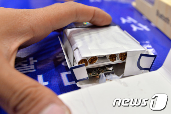 (서울=뉴스1) 신웅수 기자 = 9일 오후 서울 서대문구 경찰청에서 경찰이 담뱃갑에 숨겨진 몰래카메라를 살펴보고 있다.서울지방경찰청 사이버범죄수사대는 담뱃갑과 안경, 넥타이 등 생 …