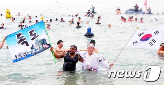 본문 이미지 - 2일 제주 서귀포시 중문해수욕장에서 열린 ‘제16회 서귀포 겨울바다 펭귄수영대회’에 참가한 도민과 관광객들이 겨울바다에서 해수욕을 즐기고 있다.2016.1.2/뉴스1 ⓒ News1 이석형 기자