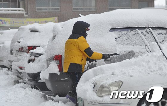 본문 이미지 - 전주를 비롯한 전북지역 전역에 30cm안팎의 폭설이 내린 24일 오전 전북 전주시 덕진구 서신동의 한 아파트에서 주민이 차량 위에 쌓인 눈을 치우고 있다. 이날 오전 8시 현재 정읍지역이 31.5cm의 기록적인 적설량을 기록한 가운데 전주에도 15.5cm의 많은 눈이 쌓였다. 2016.1.24/뉴스1 ⓒ News1 김대홍 기자