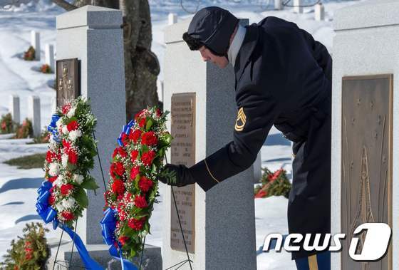본문 이미지 - 미국 육군 의장대원이 버지니아 주 알링턴 국립묘지에서 아폴로 1호와 우주왕복선 컬럼비아호, 챌린저호 폭발 사고로 숨진 우주인들의 추모행사 중 기념비에 화환을 놓고 있다. <참고사진>ⓒ AFP=뉴스1 ⓒ News1 우동명 기자
