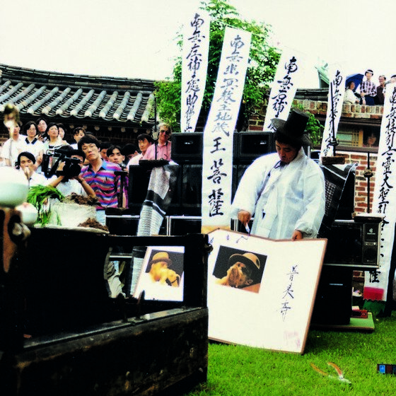 본문 이미지 - 추모굿 '늑대 걸음으로' (1990). 병풍 속에 중절모를 쓴 요셉 보이스의 사진이 있다. (사진제공 갤러리현대)