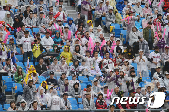 (서울=뉴스1) 임세영 기자 = 16일 오후 서울 잠실야구장에서 열린 2016 타이어뱅크 KBO리그 준플레이오프 3차전 넥센 히어로즈와 LG 트윈스의 경기에서 관중들이 우비를 입고 …