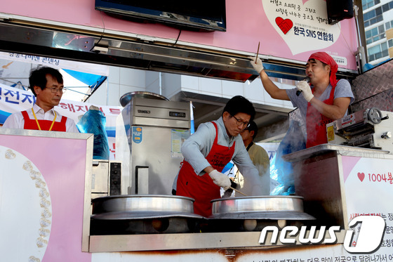 (울산=뉴스1) 이상문 기자 = 김문수 전 경기도지사가 9일 울산 중구 태화동 수해복구지역에서 ‘사랑의 짜장차’에 올라 자원봉사자와 주민들에게 자장면 봉사를 하고 있다. 2016. …