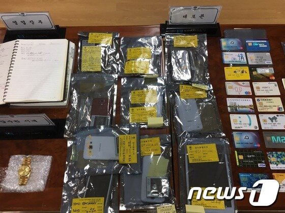 본문 이미지 - 불법 스포츠토토사이트 조직이 단속을 피하기 위해 사용한 대포폰과 차명계좌 현금카드.2016.11.10/김항주 기자 News1