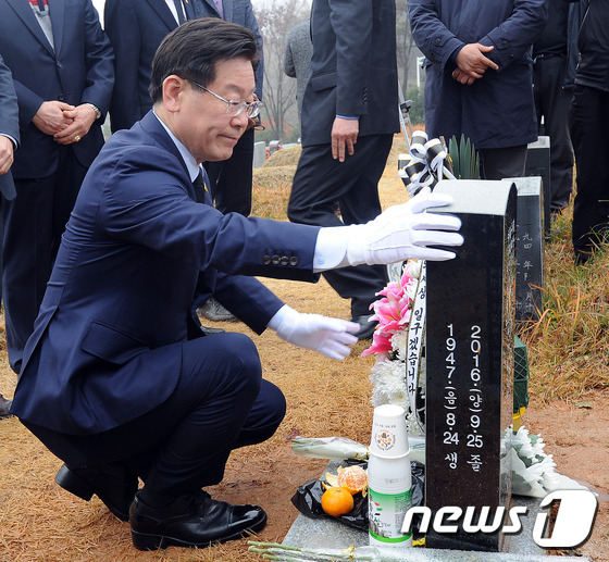 (광주=뉴스1) 윤용민 기자 = 이재명 경기도 성남시장이 19일 오후 광주 북구 운정동 국립 5·18 민주묘지에서 백남기 농민이 묻힌 묘비를 쓰다듬고 있다. 2016.11.19/뉴 …