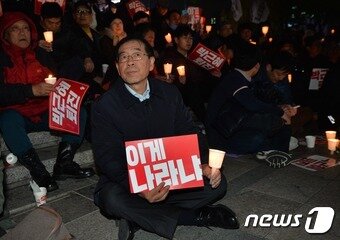 &#39;비선실세 국정농단&#39; 사태와 관련한 국민적 공분이 확산되는 가운데 2일 저녁 서울 청계광장에서 열린 민중총궐기투쟁본부 주최 박근혜 대통령 하야 촉구 촛불집회에서 박원순 서울시장이 &#39;이게 나라냐&#39;라고 적힌 피켓을 든 채 생각에 잠겨 있다. 2016.11.2/뉴스1 ⓒ News1 오대일 기자